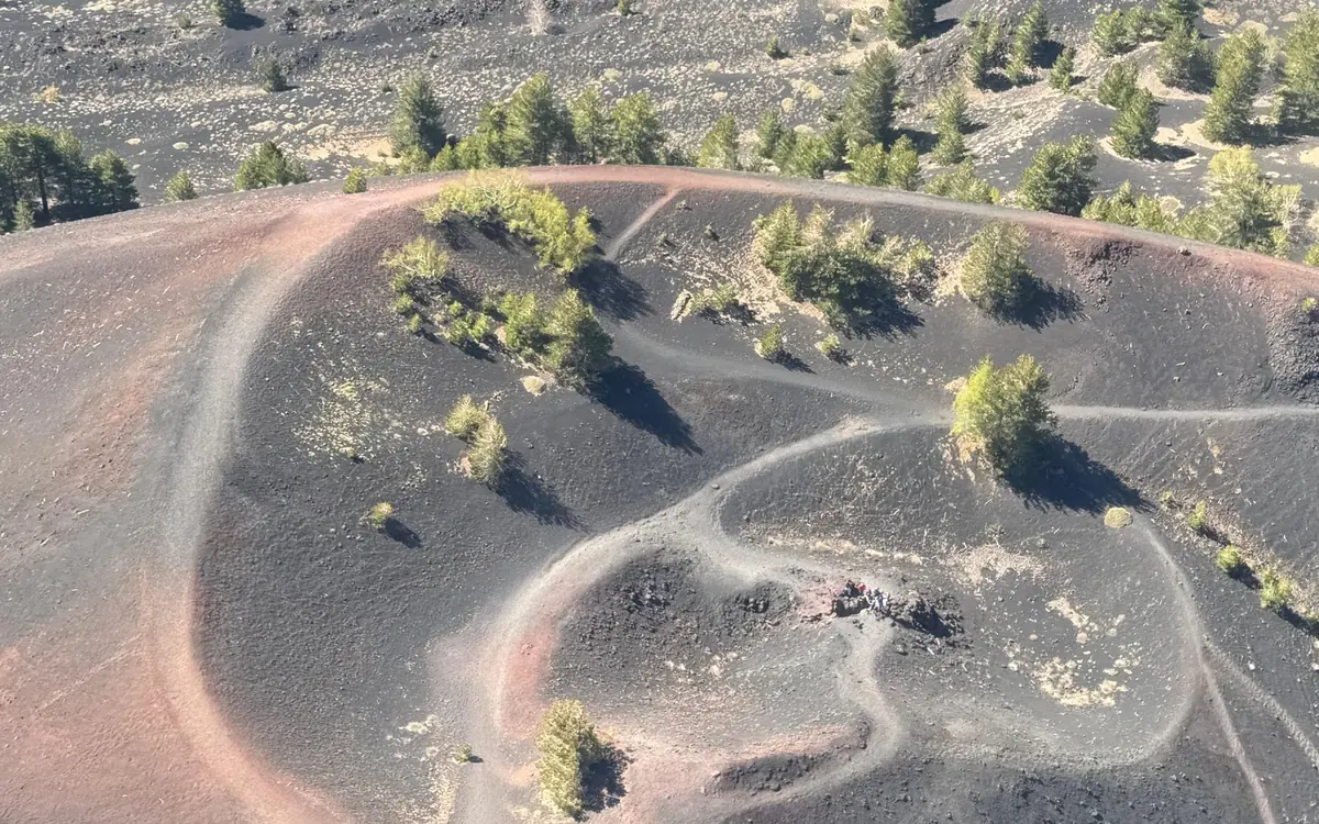The cone of Etna seen from a helicopter with the Ionian coastline far below